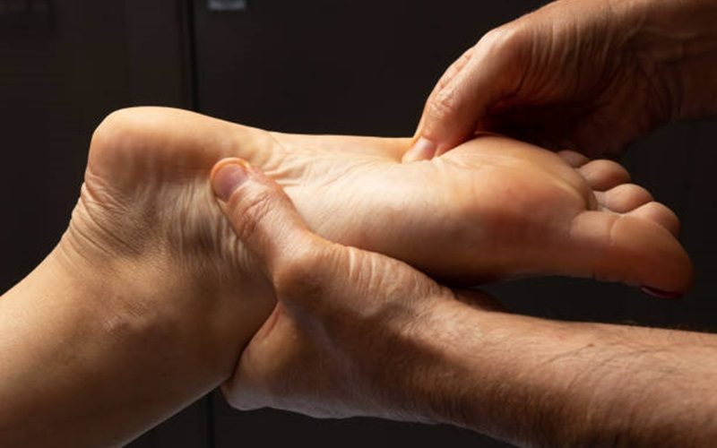 The masseur presses on the points on the foot close-up. Muscles, relaxation, body, massage, manual, recovery, pain